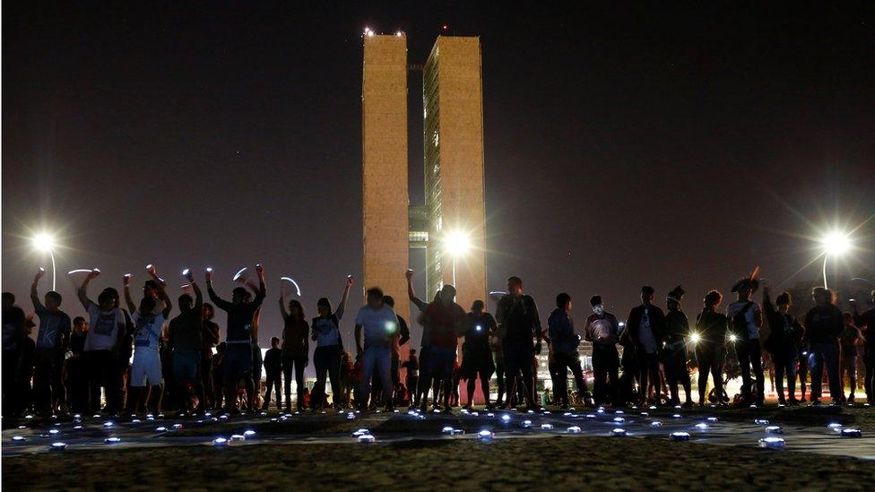 Indigenous men take part in a protest with Greenpeace activists to defend indigenous land and cultural rights