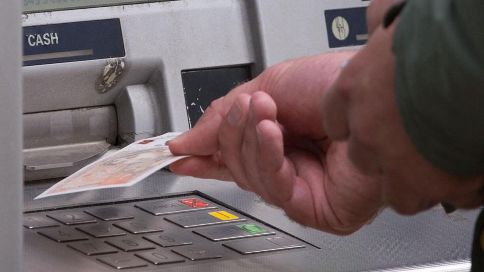 Person withdrawing cash from a machine