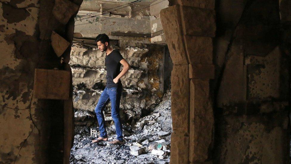 An Iraqi man looks for victims of a suicide bombing, 5 July