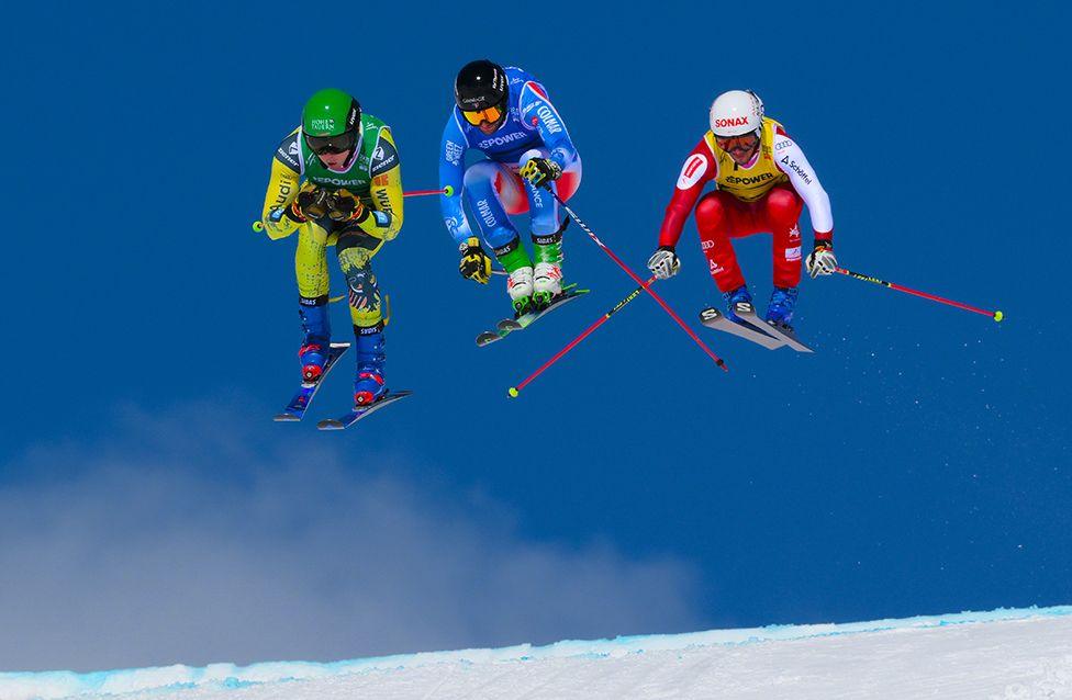 Florian Wilmsmann of Germany, Melvin Tchiknavorian of France and Adam Kappacher of Austria compete during the Mixed Team Ski Cross semi-final at the World Championships on 22 March in Switzerland.