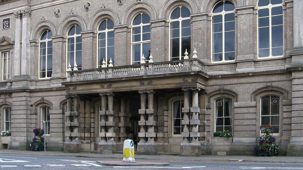 Exterior of the two-storey Grimsby Town Hall showing its light stone with columns around the doorway supporting a balcony