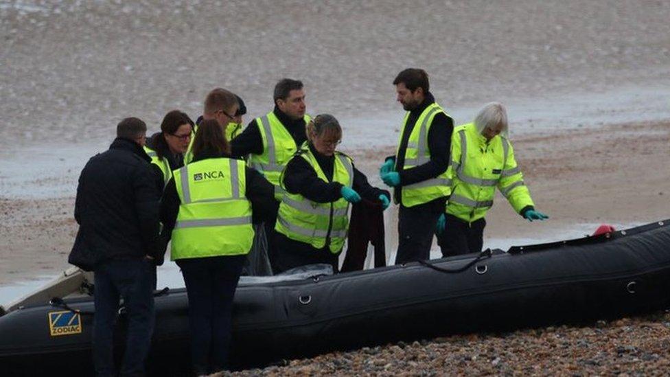 National Crime Agency officers examine a boat at Greatstone beach in Kent that arrived carrying 12 migrants on 31 December 2018