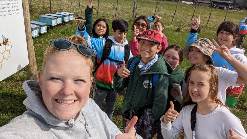 A photo of Beth and her pupils smiling on a school trip