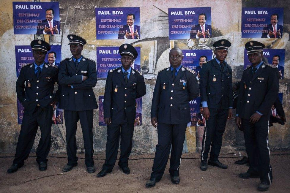 Policemen wait in the shade after Cameroon's president Paul Biya's electoral meeting in Maroua