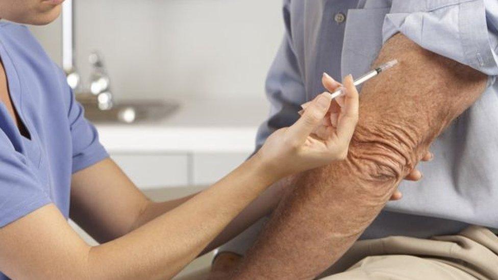 A medic gives a man an injection