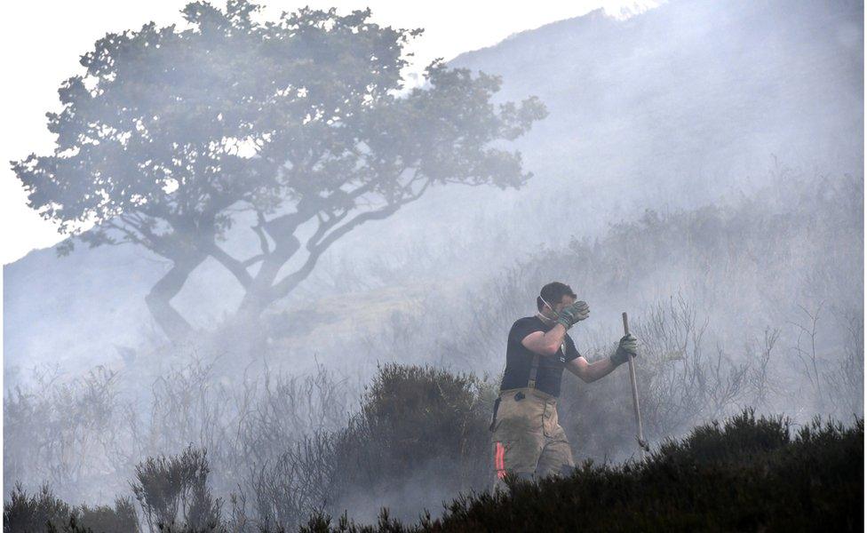 Fire fighter tackling the blaze above Stalybridge, Greater Manchester