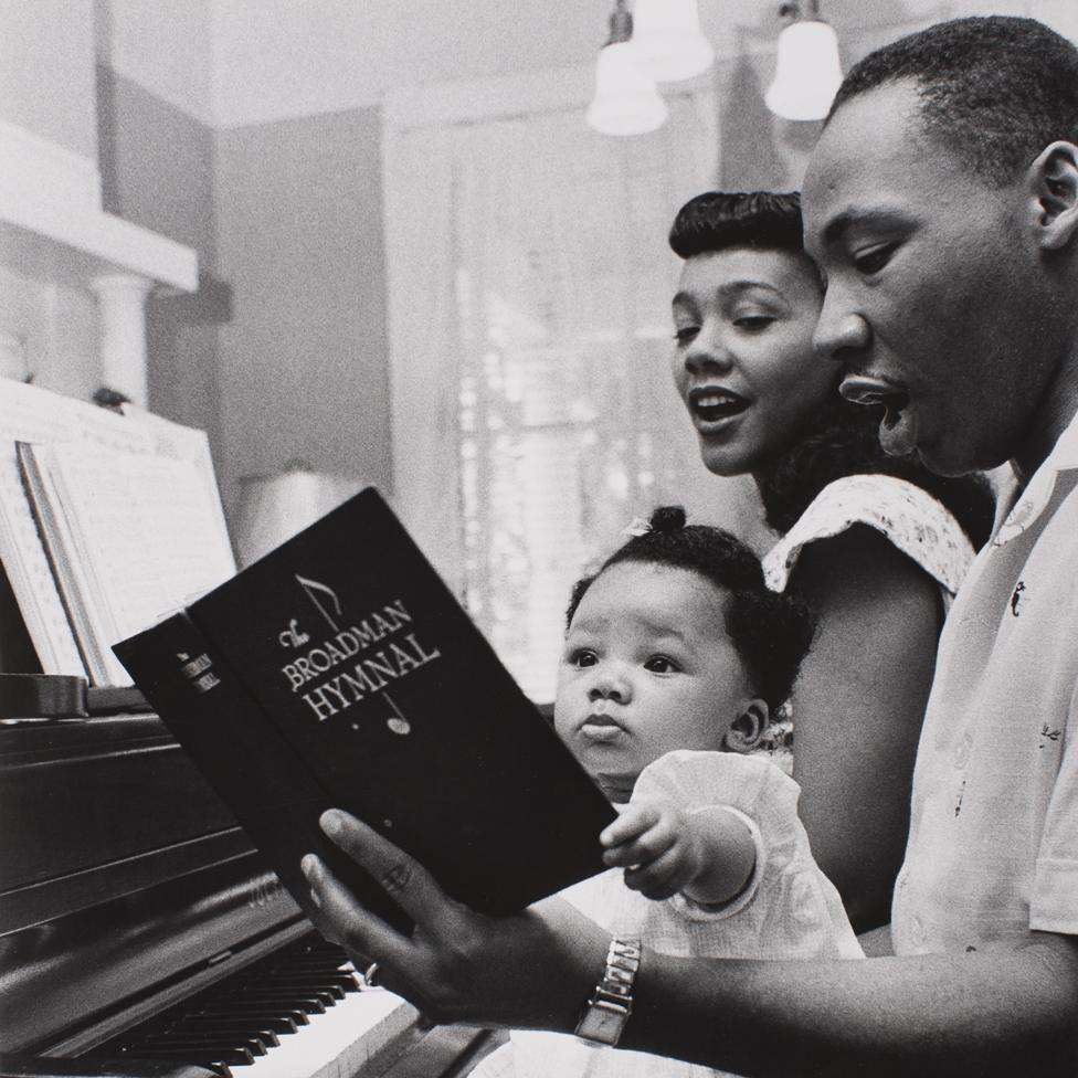 Coretta Scott King, Martin Luther King and one of their children sing a hymn at the piano - Montgomery, 1956