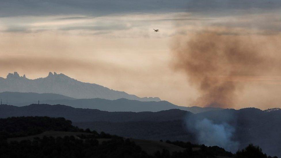 A hydroplane flies over the Sierra de Bellprat in Barcelona province