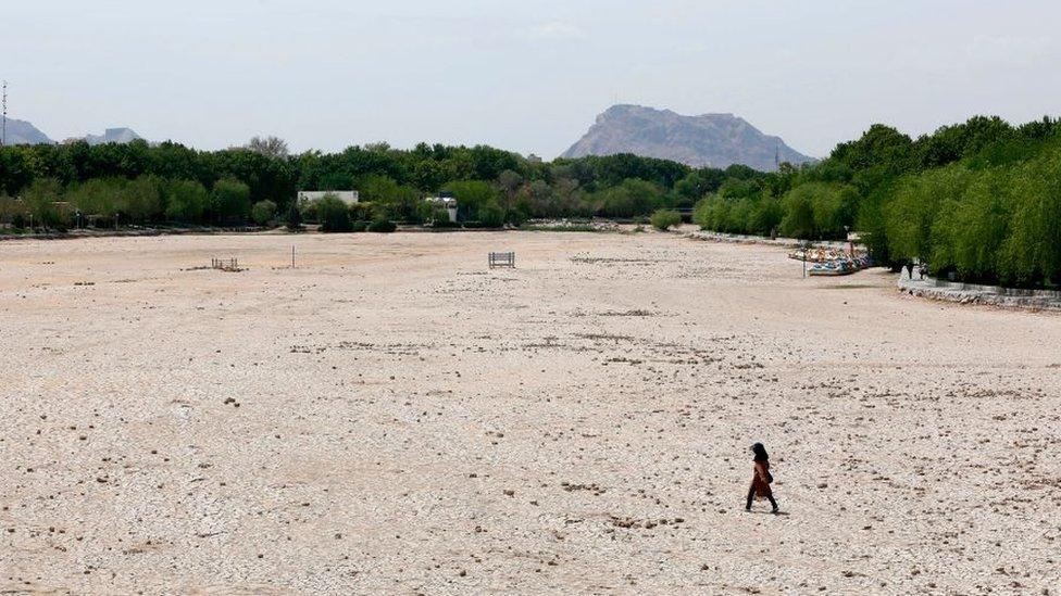 A figure walks over the dried Zayandeh Rud river in Isfahan in 2018