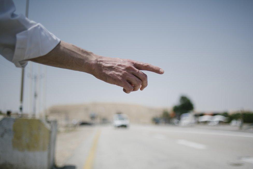 An Orthodox Jewish man looks out for arriving cars as he waits for the bus at the Nahshon bus junction in Nahson, Israel