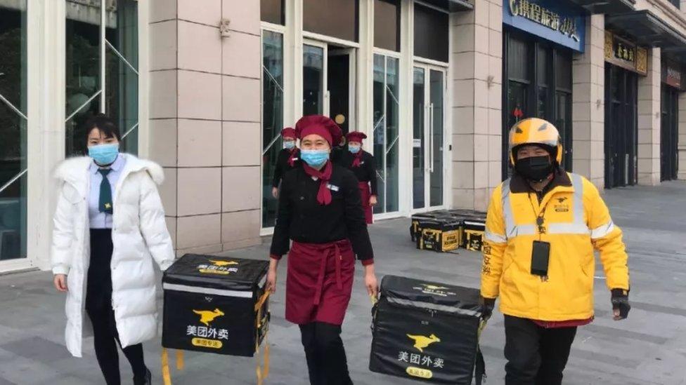 Hospital staff carrying food