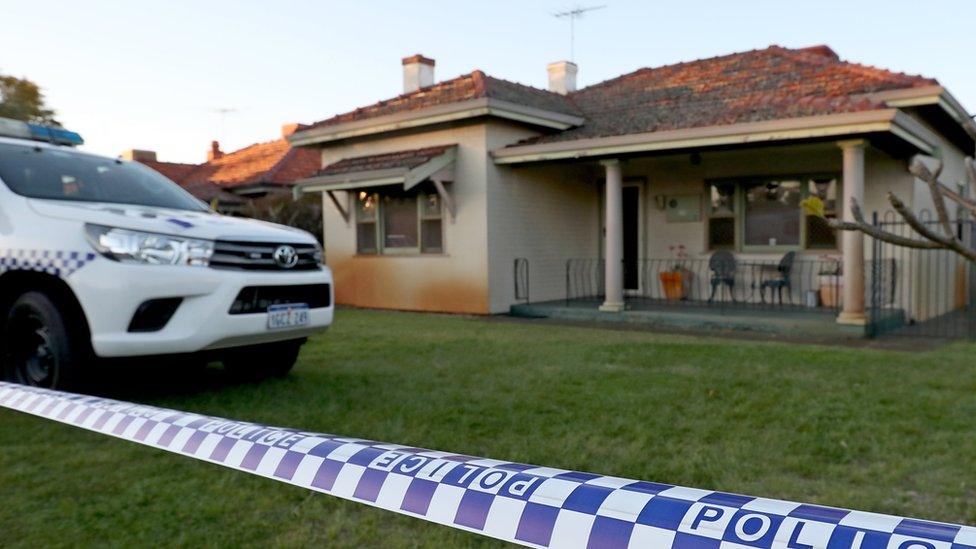 A police car outside the home where five people were found dead