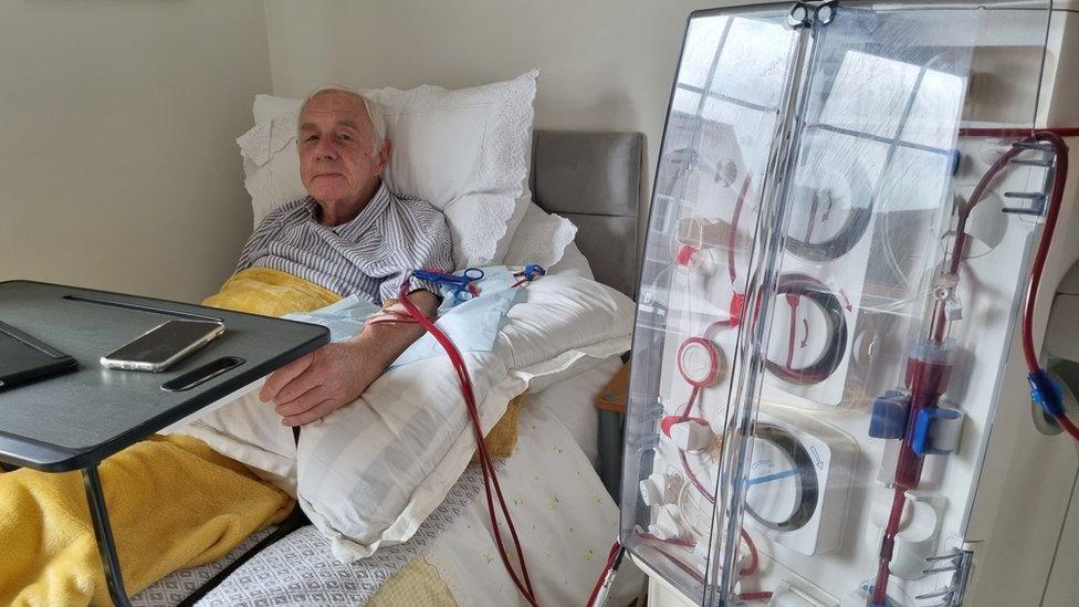 Image of a man in bed connected to a dialysis machine