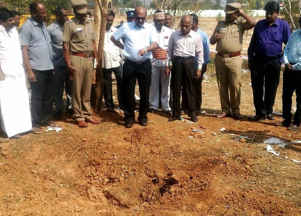 Indian authorities inspect the site of a suspected meteorite landing on February 7, 2016 in an impact that killed a bus driver and injured three others on February 6