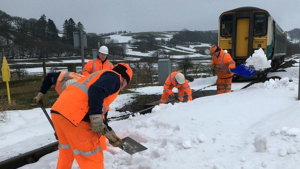 Railway workers clear snow from the Heart of Wales line