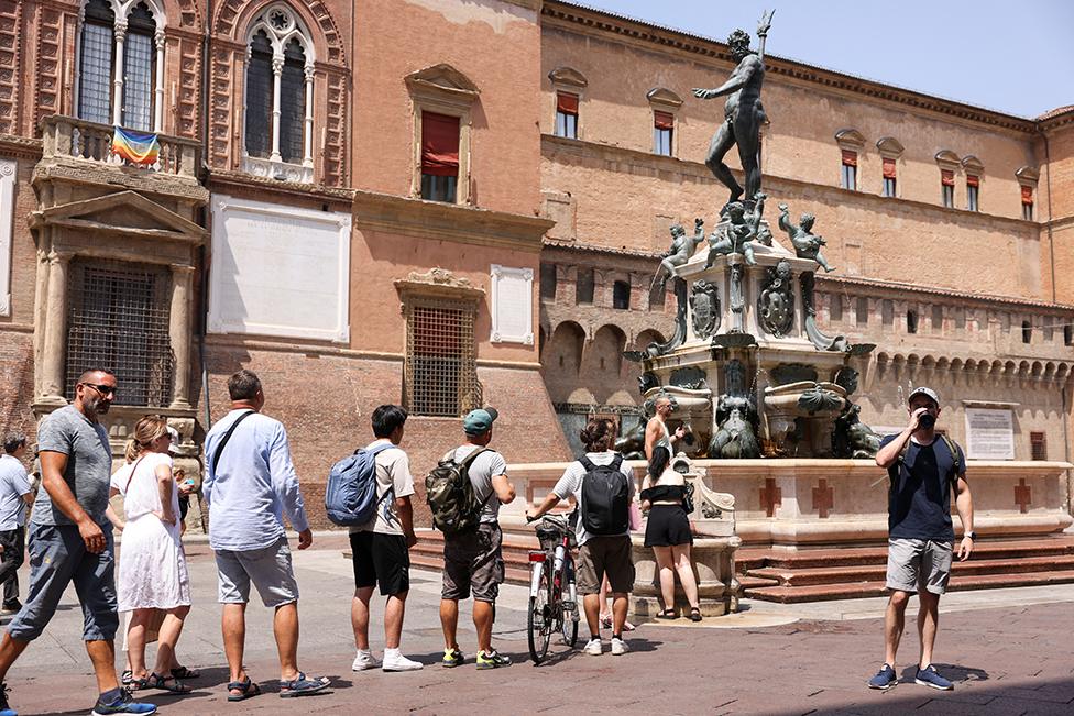 People queue to refill their water bottles at the Fountain of Neptune in Bologna, Italy, on 18 July 2023