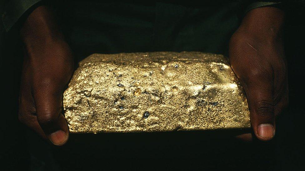 Man holding a gold ingot