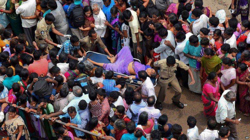 A woman is rushed to a hospital on a stretcher after a stampede during a Hindu religious bathing festival on the bank of the Godavari River in Rajahmundry, Andhra Pradesh state, India, Tuesday