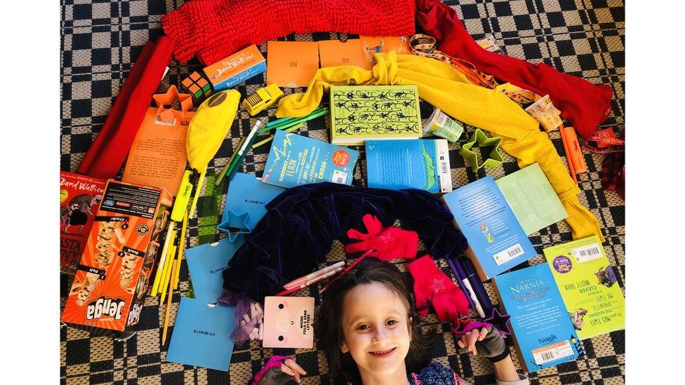 girl-lies-on-floor-underneath-rainbow-made-of-her-favourite-things