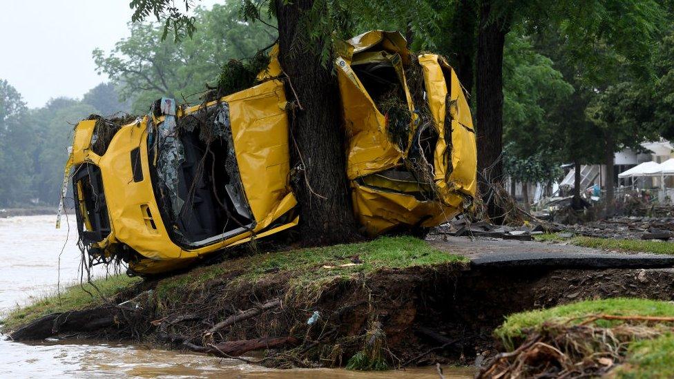 A van crushed by the torrents is pressed against a tree in Germany