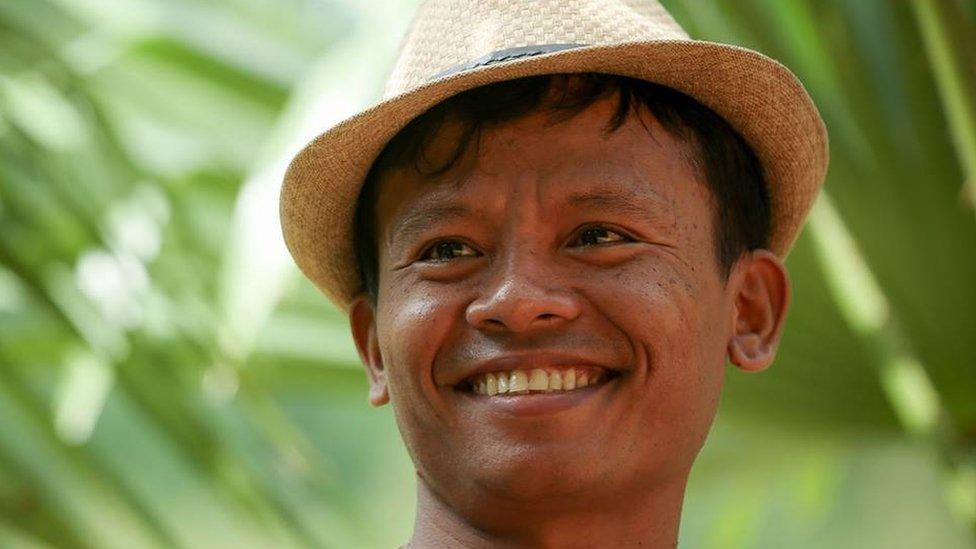 Lawi Weng, smiling and wearing a hat