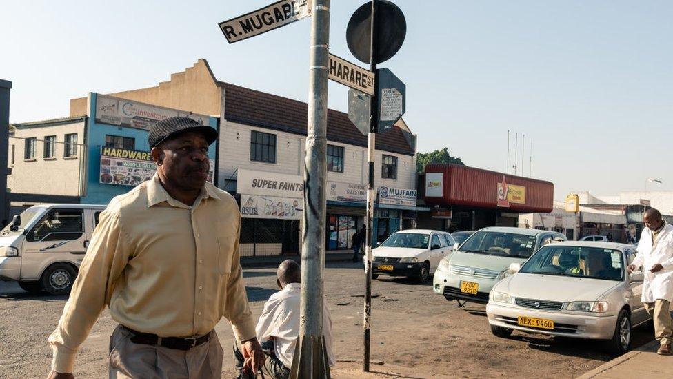 Pedestrians walk along Robert Mugabe Road in the capital Harare on September 6, 2019