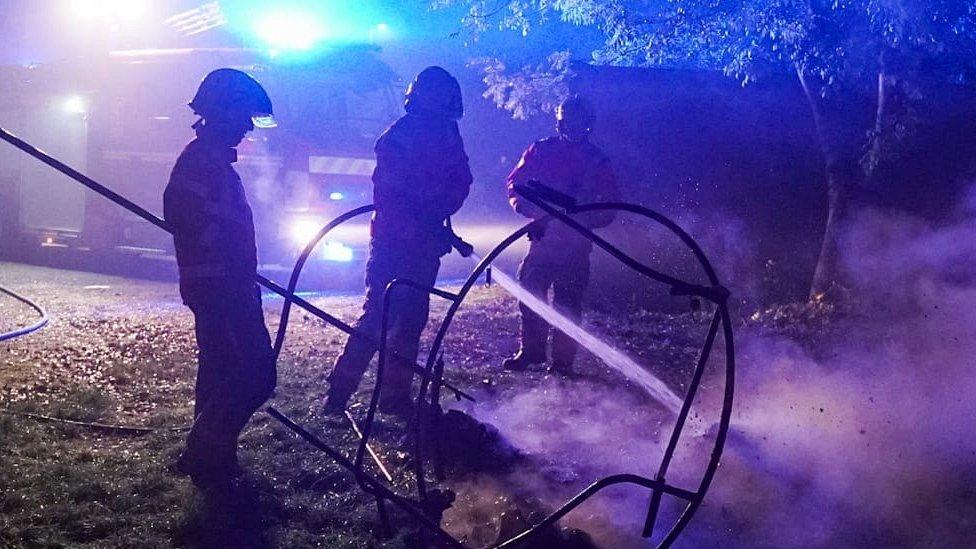 three firefighters extinguish flames