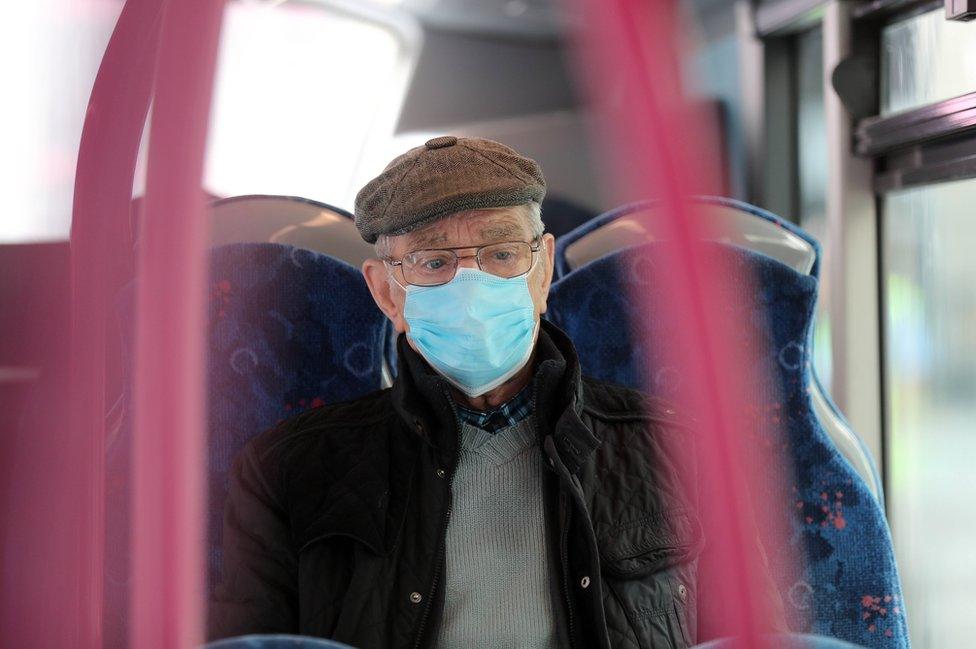 A elderly man wears a protective face mask on a bus in Belfast