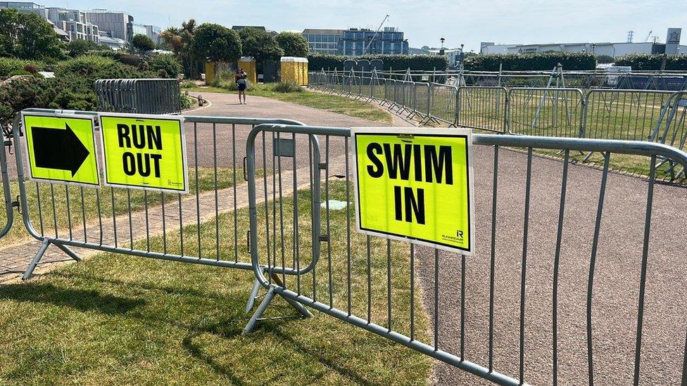 Signs saying run out, swim in on a railing in Jersey