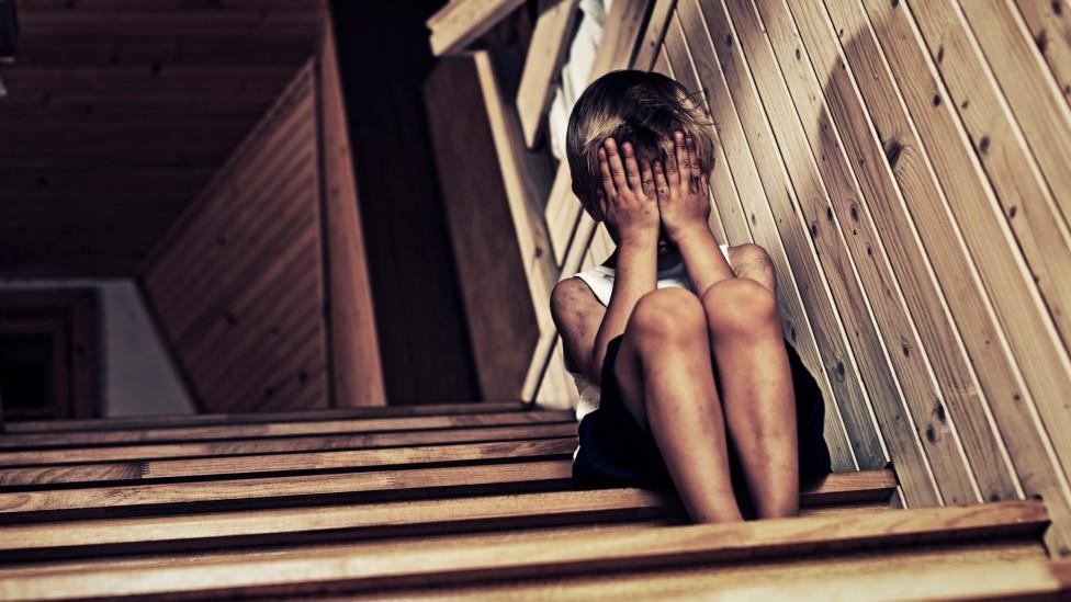 Stock image of child with hands covering face