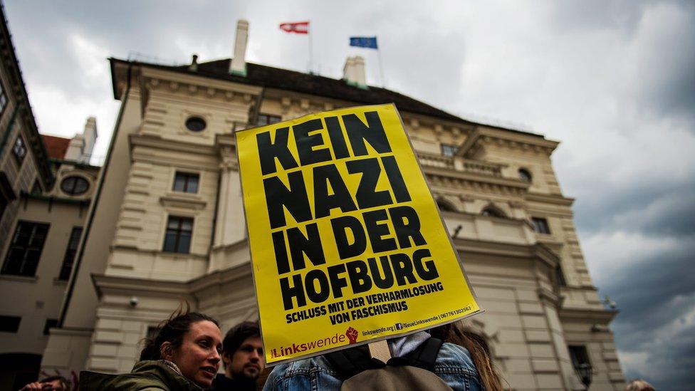 A protester holds a sign reading "No Nazis in Hofburg palace"