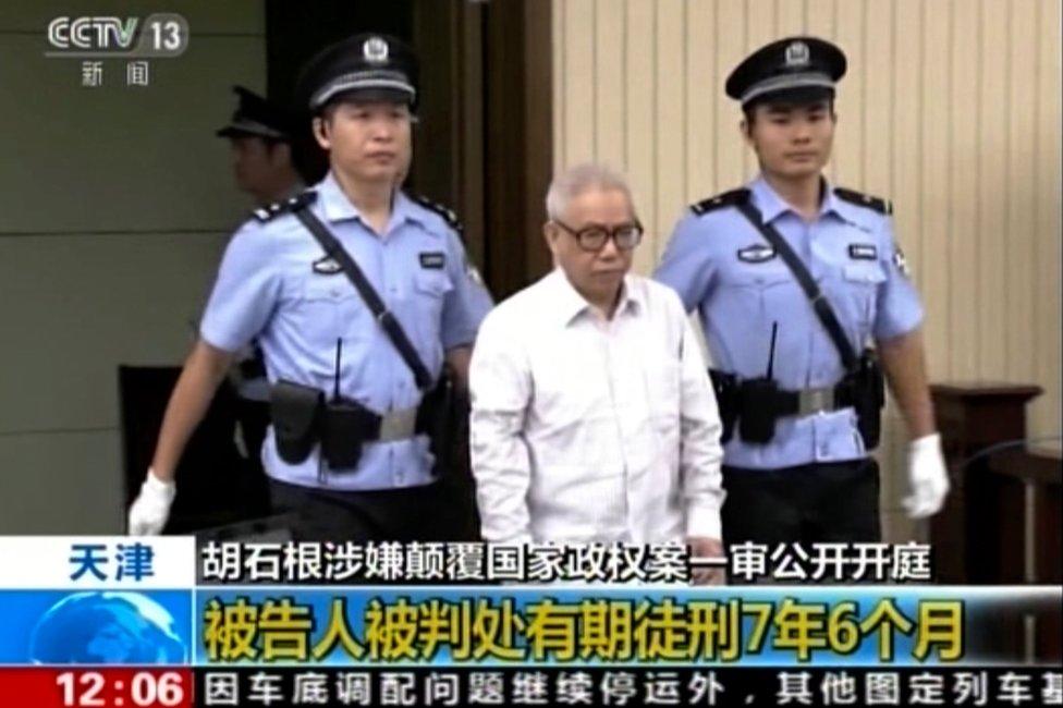 In this image from video released on 3 August 2016 Chinese legal rights activist Hu Shigen, centre, is escorted by police officers upon his arrival for his trial at the Tianjin No. 2 Intermediate People's Court.