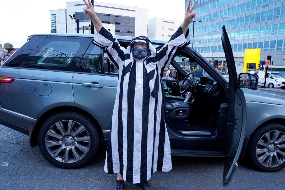 Fan dressed in black and white Saudi clothing