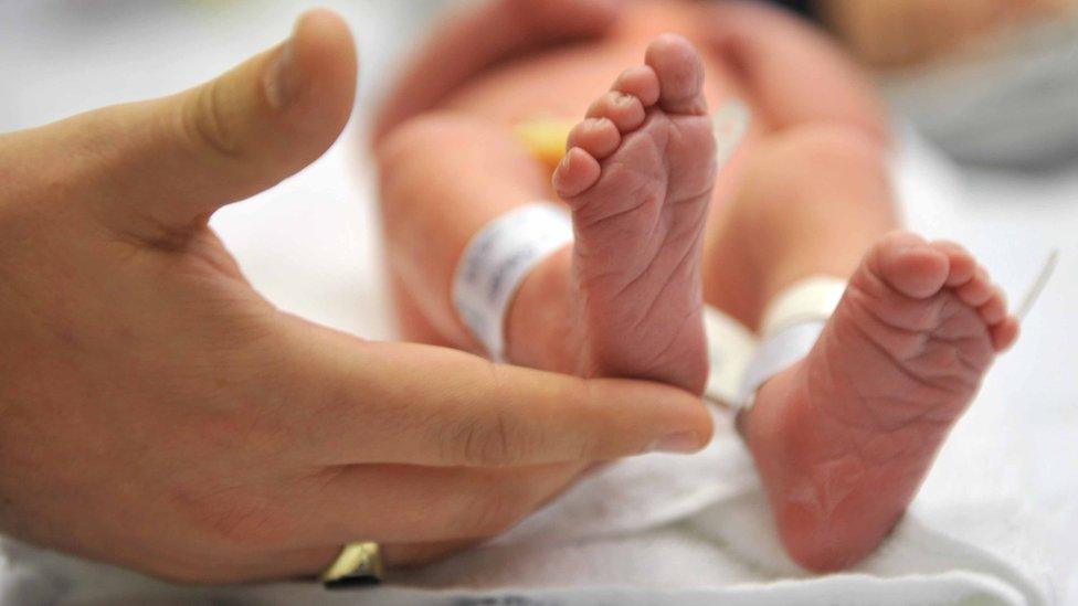 Hand and baby's feet