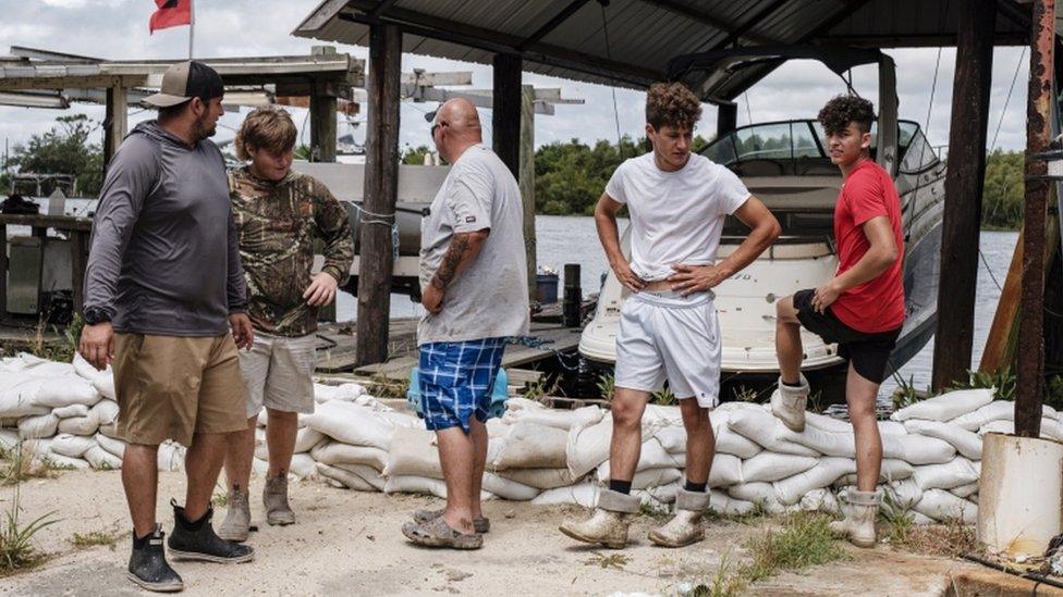 Volunteers inspect a line of sand bags in Jean Lafitte, Louisiana