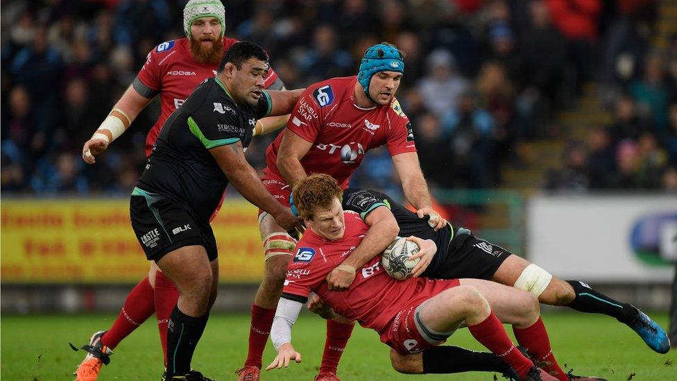 Rhys Patchell (Scarlets) is tackled by an Ospreys player