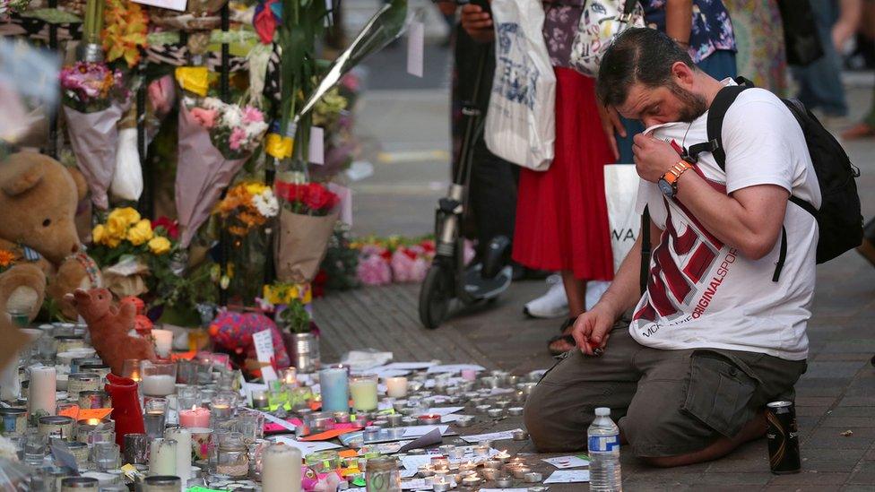 People look at tributes at Notting Hill Methodist Church near Grenfell Tower