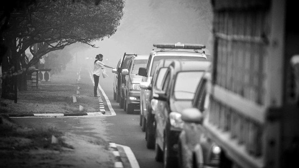 A volunteer distributes N95 masks to motorists in Kalimantan