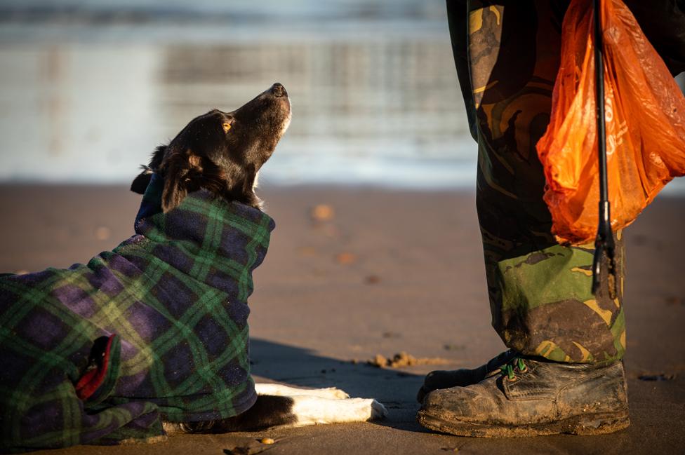 Cariad and Stewart (carrying litter picker and plastic bag) on the beach in Whitby