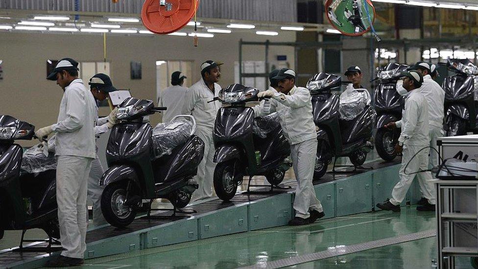 Indian skilled workers work on an assembly line for Honda Activa scooters at the new plant in Vithalapur, some 80 km from Ahmedabad on February 17, 2016. It is the fourth HSMI plant in India and the first scooter plant