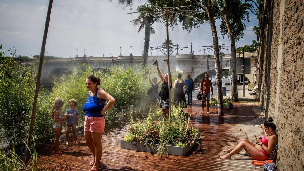 People enjoy spraying water as a heat wave rolls over Paris, France