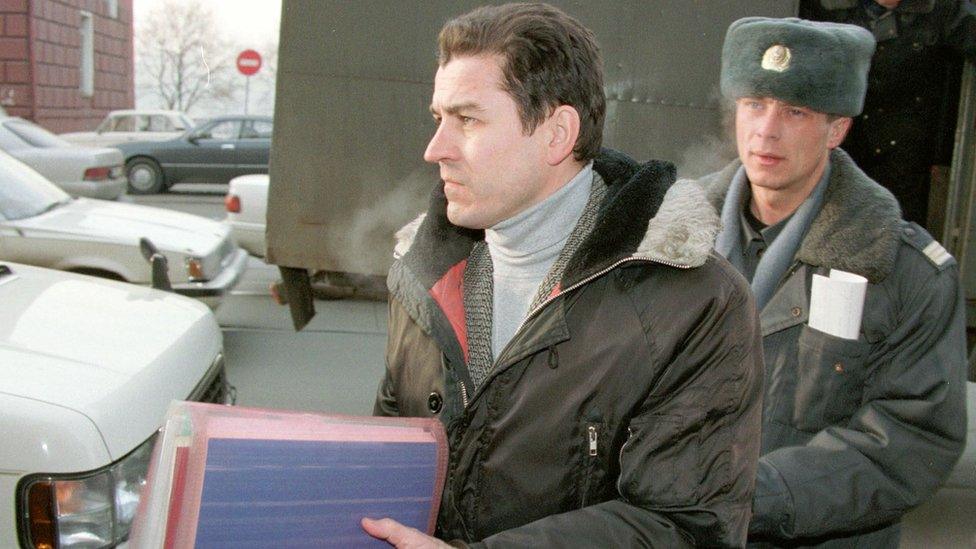 Military journalist Grigori Pasko (L) leaves a car escorted by a militiaman as he arrives at court in Vladivostok 21 January 1999