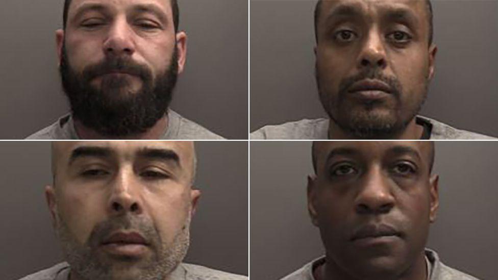 A composite image showing police custody shots of four men, all with serious expressions, in front of a dark-grey backdrop. They are wearing light-grey T-shirts. One has a full, dark-brown beard. Two have stubble. One is clean shaven.