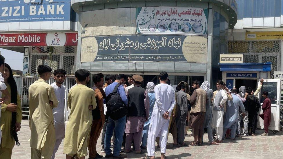 Afghan people line up outside AZIZI Bank to take out cash as the Bank suffers amid money crises in Kabul