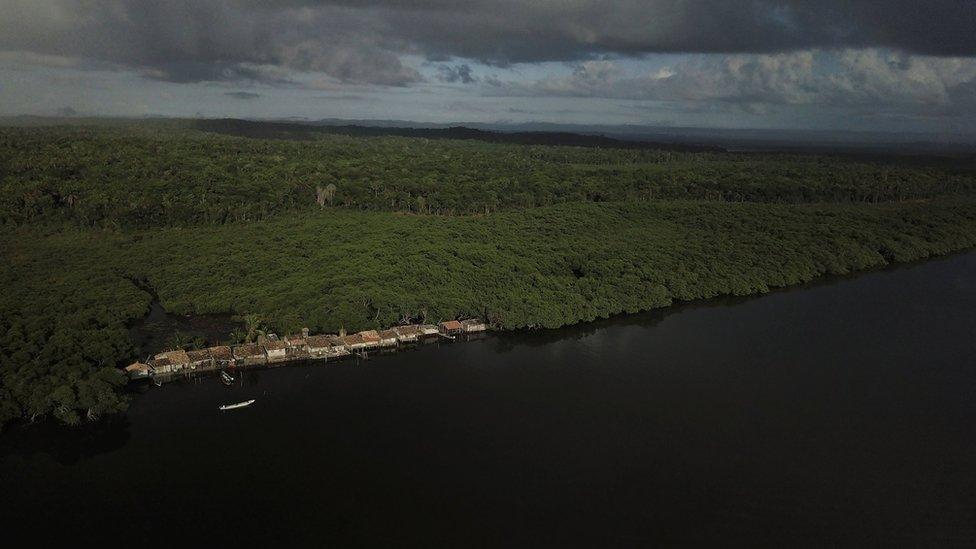 Aerial shot of a collection of houses by the Caratingui river in Brazil