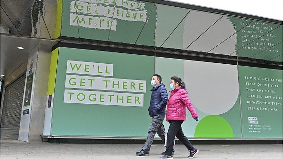 Couple walk past closed shop