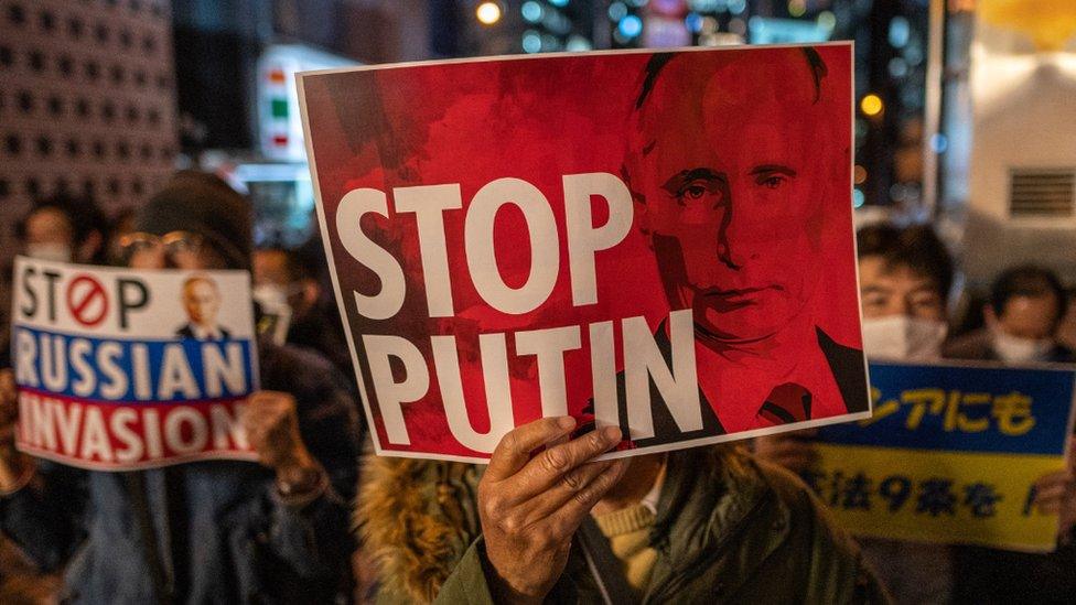 People hold up placards as they take part in a protest against Russia's actions in Ukraine, during a rally near the Russian Embassy in Tokyo on March 4, 2022.