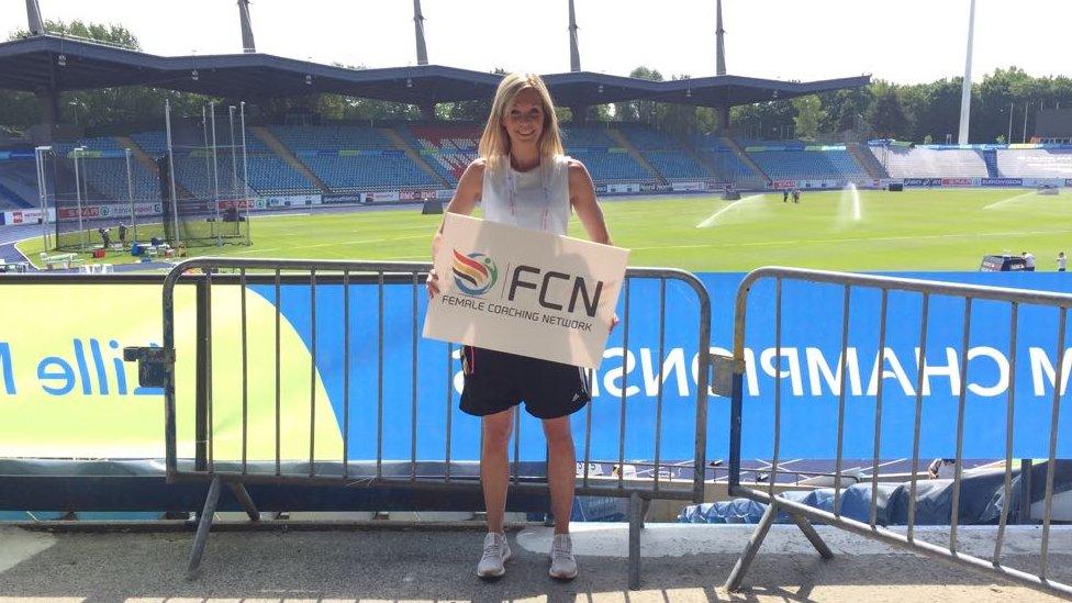 Vicki posing with a sign for the Female Coaching Network