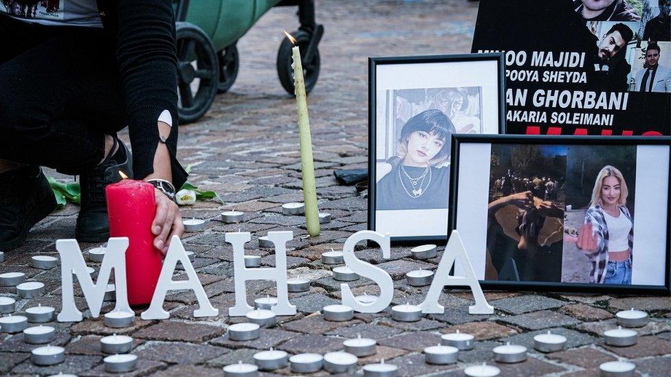 A person places a candle during a demonstration in solidarity with the protesters.