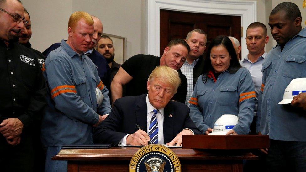 U.S. President Donald Trump signs a presidential proclamation placing tariffs on steel and aluminium imports while surrounded by workers from the steel and aluminium industries at the White House in Washington, U.S. March 8, 2018.